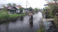 Arungi Jalan Banjir Imbas dari Hujan Deras, Bhabinkamtibmas Polsek Bangko Patroli dan Sosialisasi Pemilu Damai