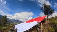 Satgas Yonif 323 Buaya Putih Kibarkan Bendera Raksasa di Atas Ketinggian Bukit Cakra Papua